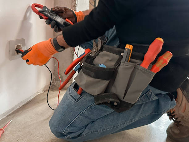 Electrician hands holding a digital clamp tester at home
