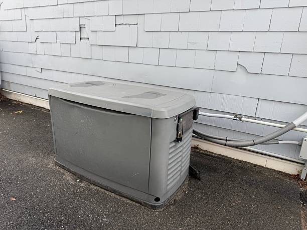 A Home Standby Generator installed at the backyard of a house. An air-cooled natural gas or liquid propane generator for residential use
