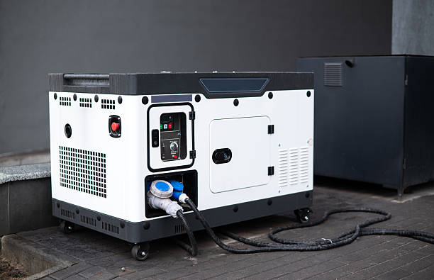 Portable diesel generator with power cables outdoors near building, backup electricity equipment