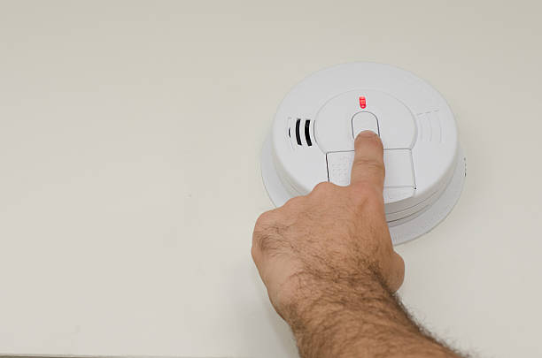 Pressing button on residential smoke detector