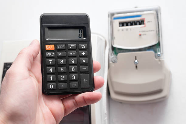 Calculator and electric meter on the wall. Calculation of electricity costs concept.