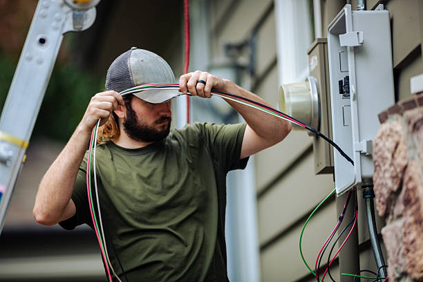 A professional solar technician installing a Solar Panel Electric Box on the side of a house
